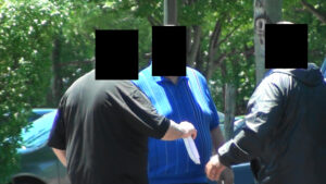 A man in blue shirt holding a frisbee.