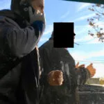A man on the phone with his hand in his mouth.