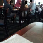 A group of people sitting at tables in a restaurant.