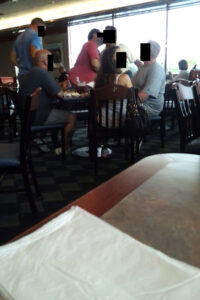 A group of people sitting at tables in a restaurant.