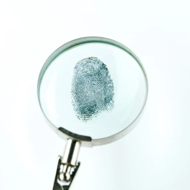 A magnifying glass with a fingerprint on it.