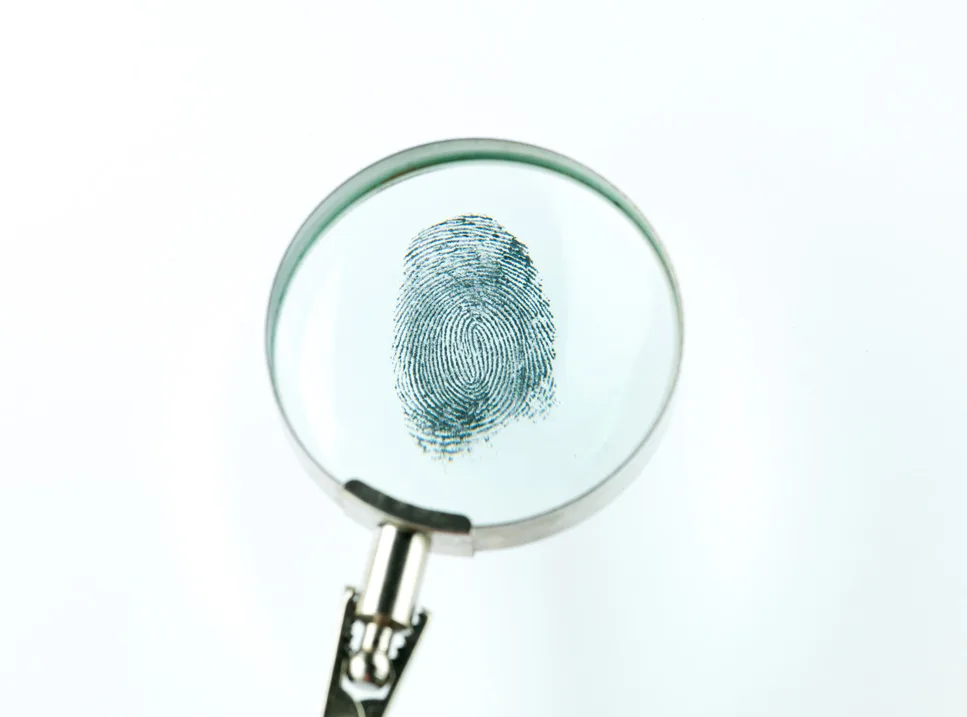 A magnifying glass with a fingerprint on it.
